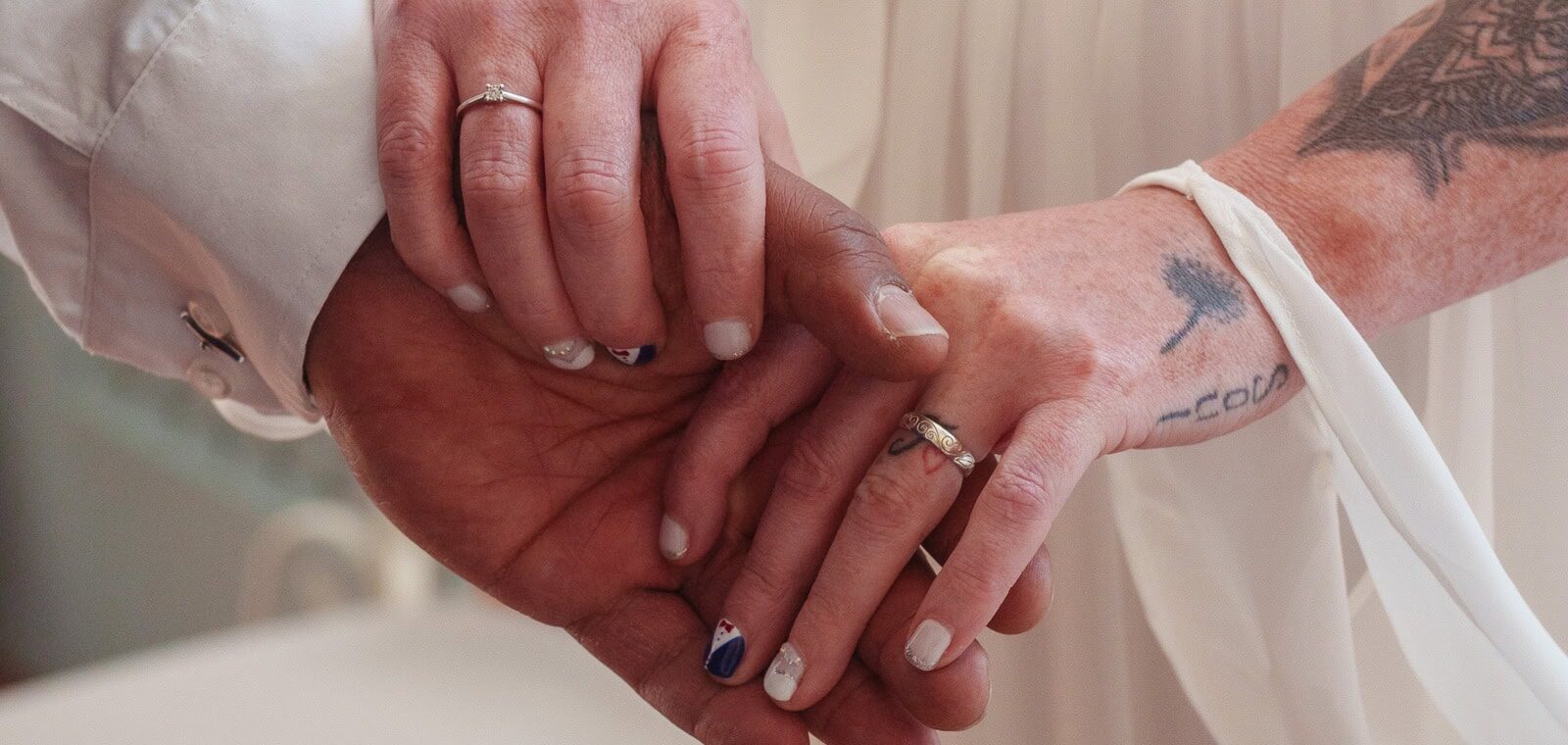 Close-up of two people holding hands on their wedding day