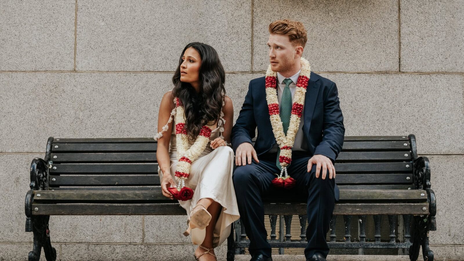 Couple sitting on a bench outside Chelsea Old Town Hall after eloping