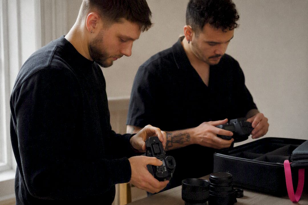 Two photographers checking backup camera bodies