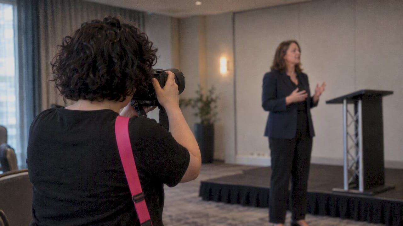 Photographer capturing a conference speaker