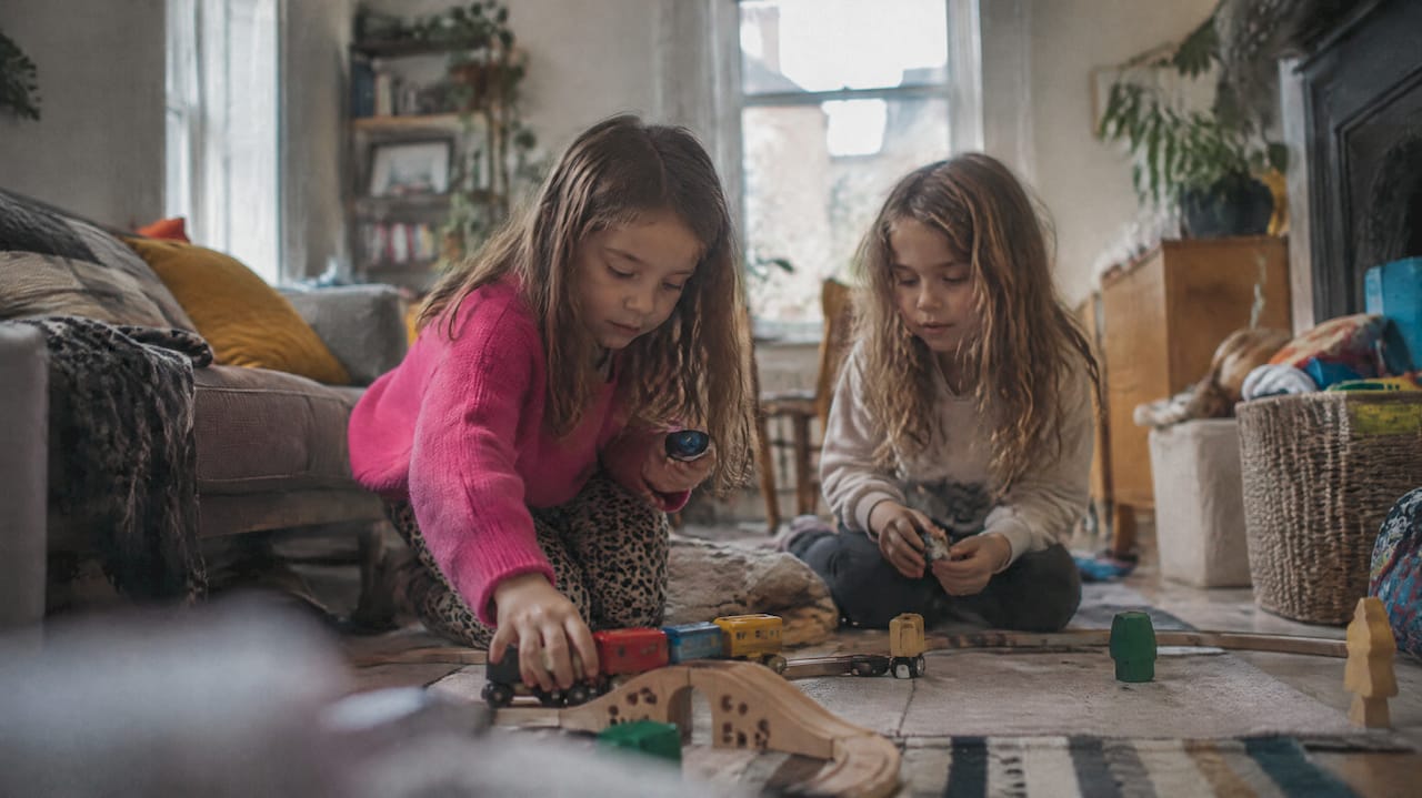 Two girls sharing a toy tour at home
