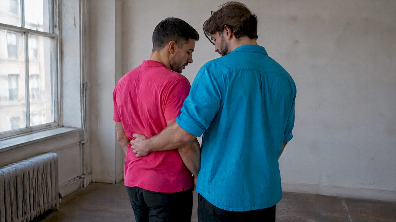 Queer couple settling into a portrait pose