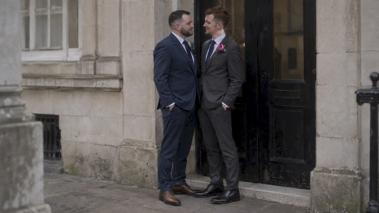 Two grooms pause for a wedding portrait